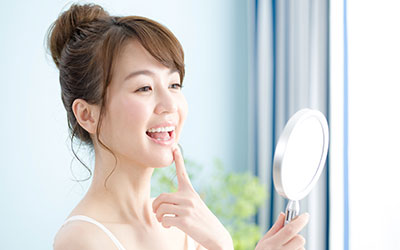 手鏡で歯並びを確認する女性